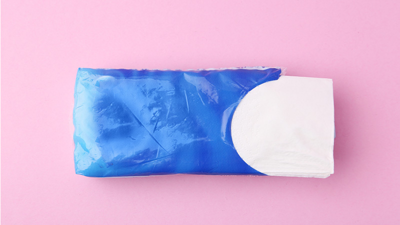 Fazzoletti di carta in pacchetto su sfondo rosa, vista dall'alto